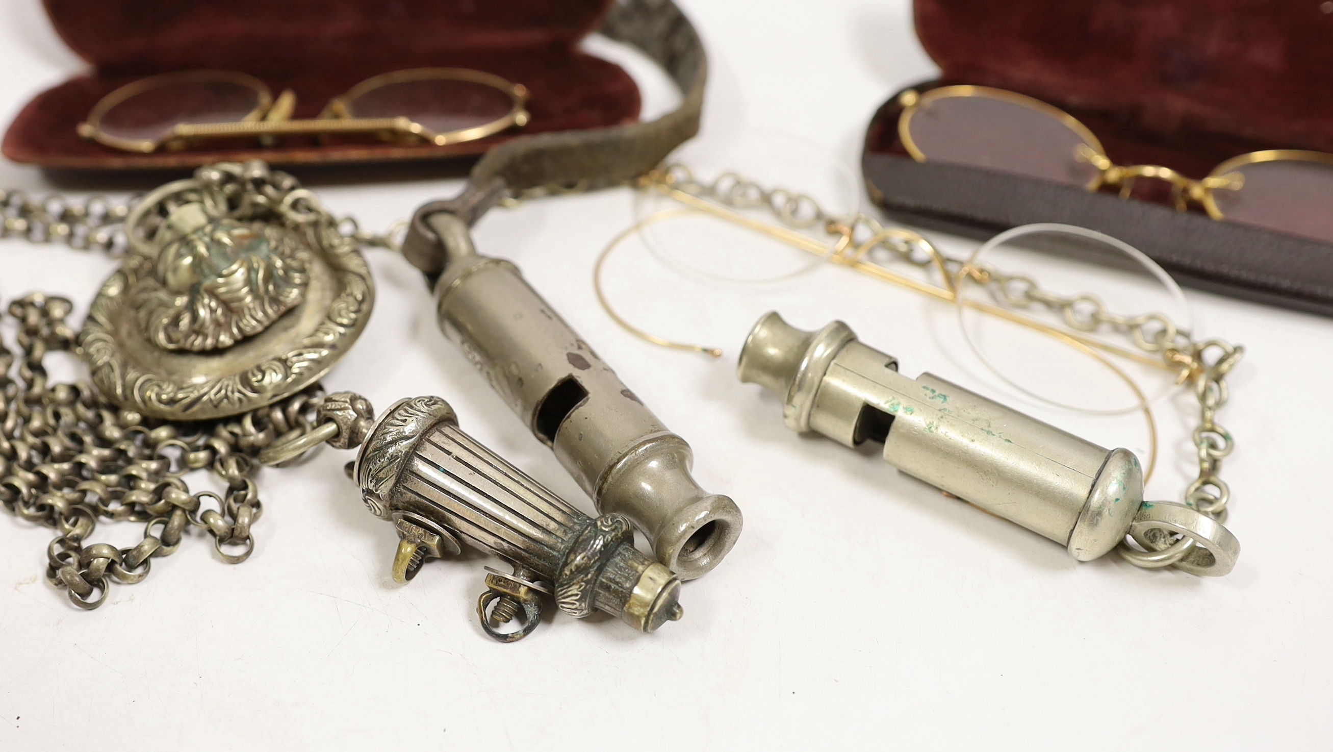 Three pairs of pince-nez and three police whistles